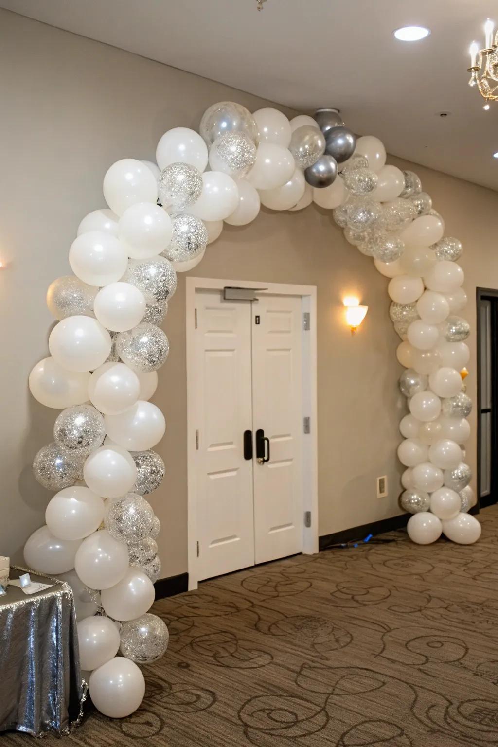 Celebrate in style with a stunning white and silver balloon arch.