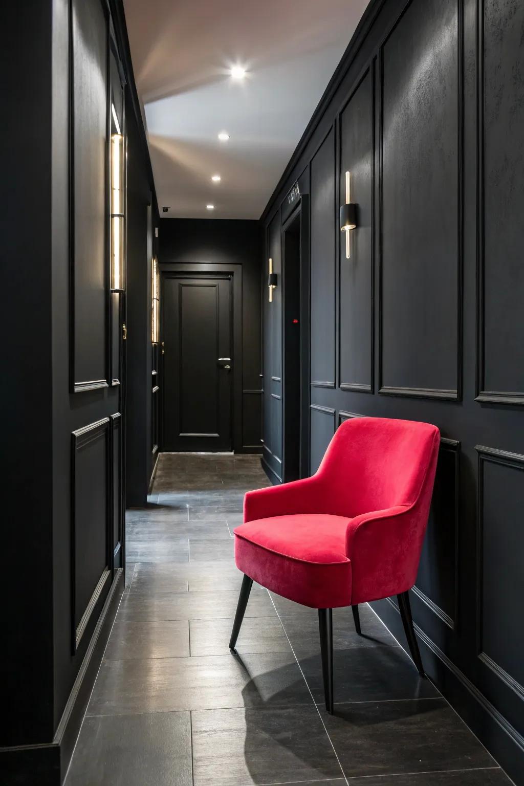 A bold-colored accent chair adds personality to a black hallway.