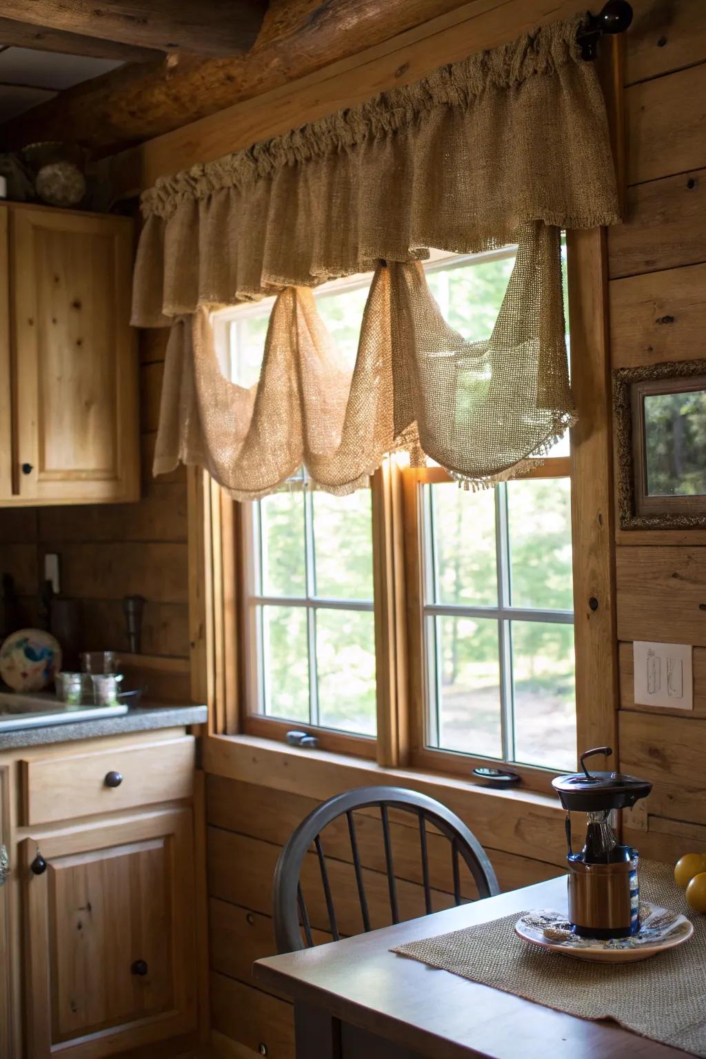 A cozy kitchen with a burlap valance that complements the rustic wooden elements of the space.