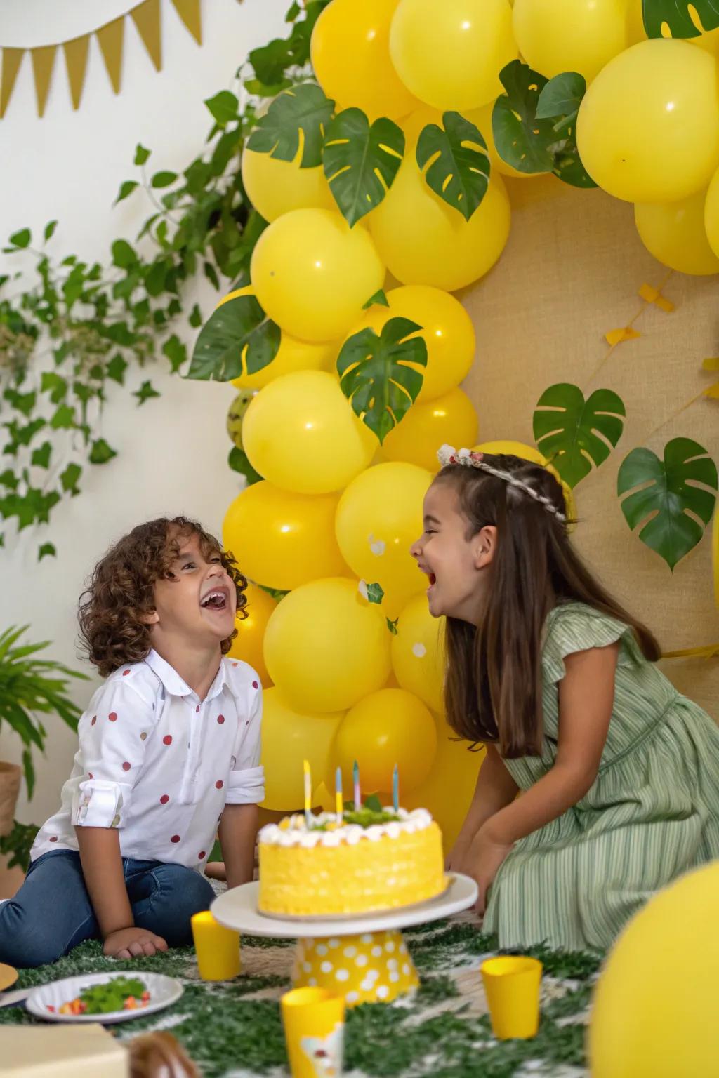 A photo-ready yellow balloon backdrop with greenery.