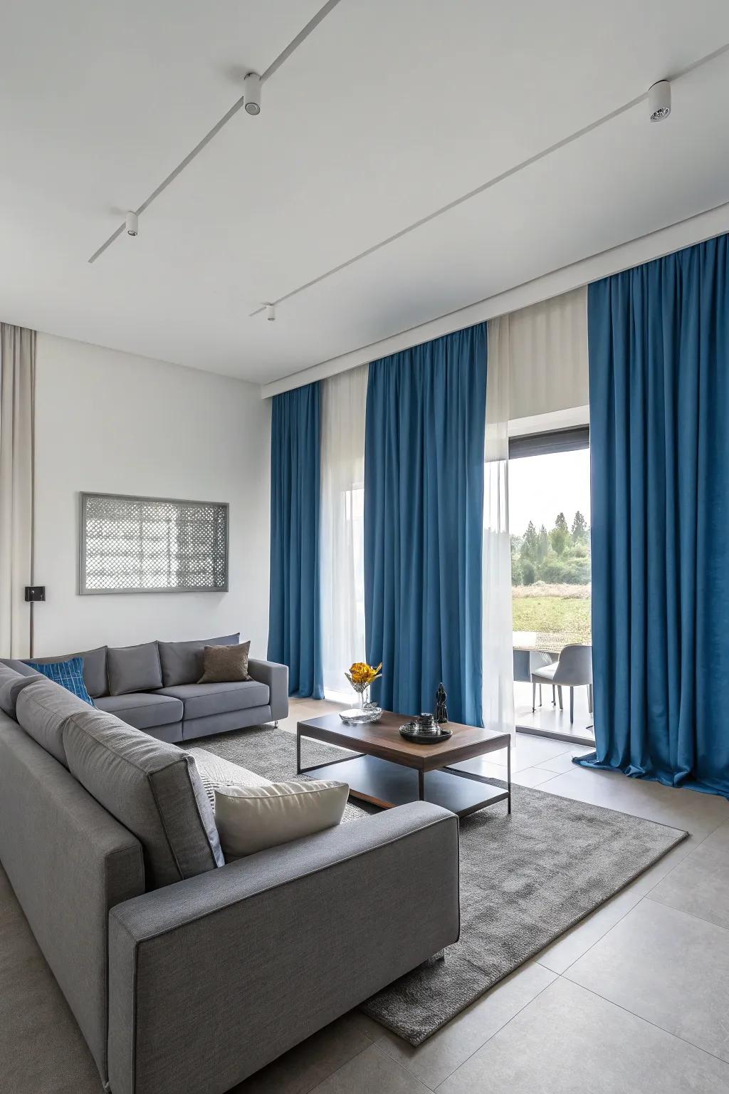 Blue curtains and gray furniture create a modern, harmonious living space with a balanced color palette.