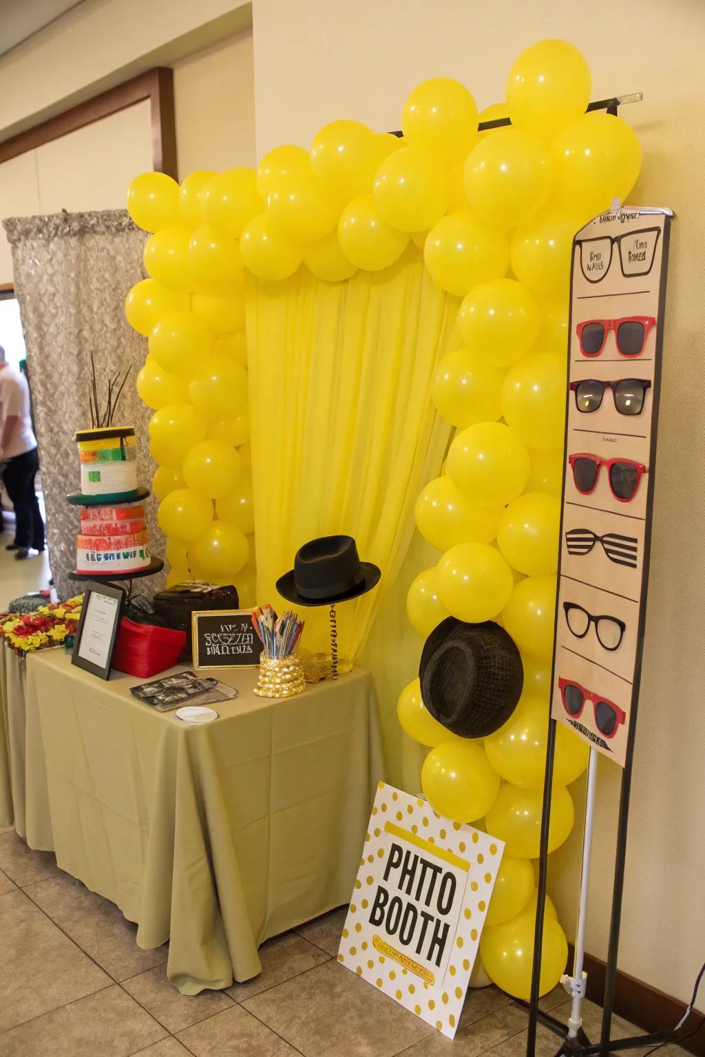 Photo booth with a fun yellow balloon backdrop.