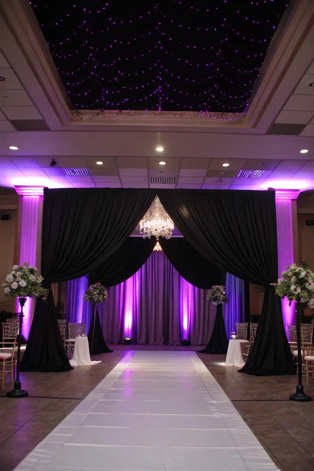 Dramatic lighting with purple uplighting and black drapery.